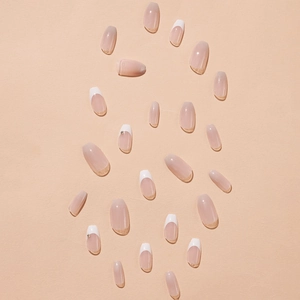 French tip press-on nails in nude pink with delicate rhinestone accents and white borders