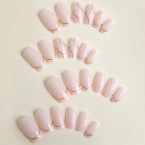 Pink press-on nails set with elegant gold glitter lines and star patterns on fabric
