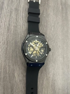 Macro view of automatic mechanical watch featuring a black skeleton dial and golden gears