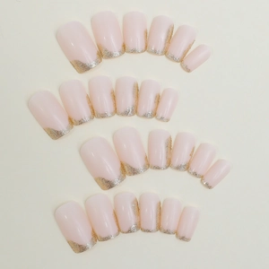 Handmade nude pink press-on nails with golden glitter French tips in rectangular shape