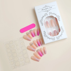 Detail view of pink gradient press-on nails set with glitter, adhesive tabs and file