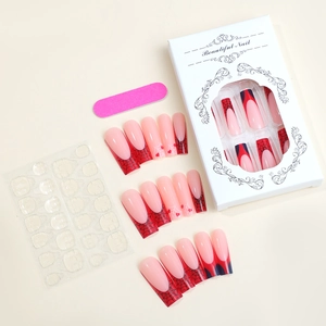 Détail de faux ongles cercueil rouges avec toiles d'araignée et motifs de cœur dans un coffret