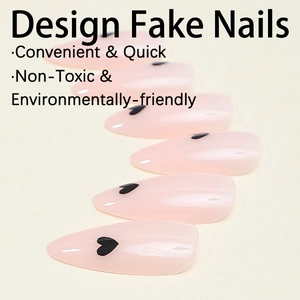 Close-up of almond-shaped light pink press-on nails featuring minimalist black heart patterns