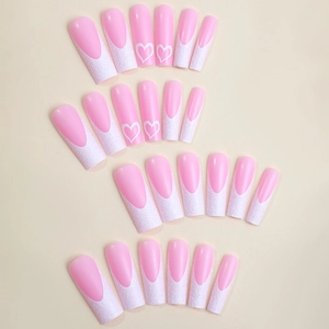 White French tip press-on nails with pink base and glitter heart patterns in coffin shape