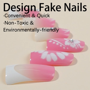 Faux ongles dégradés roses avec motifs de fleurs blanches et strass brillants
