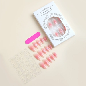 Detail of almond nails with pink gradient, hearts, bows, and professional tool kit