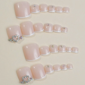 French press-on toe nails with rhinestones and hollow heart design on nude pink finish