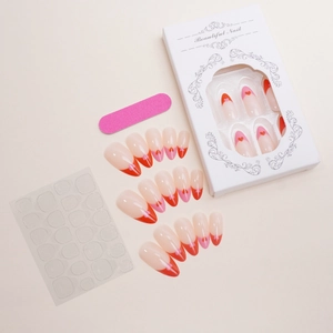 Detail of almond press-on nails with red pink french tips and heart patterns in a gift box