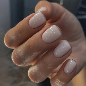 Macro shot of creamy white glossy press-on nails with a sleek square round shape
