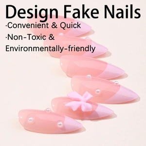 Faux ongles dégradés roses avec nœud 3D et perles décoratives sur fond blanc