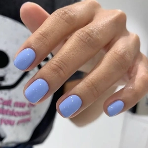 Detailed view of light blue glossy handmade press-on nails with a square shape finish
