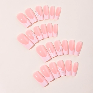 Long coffin fake nails with pink gradient design and 3D white floral decorations