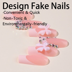 Faux ongles French roses avec nœuds 3D et strass présentés sous un angle de 45 degrés