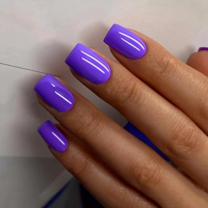 Macro shot of glossy bright purple short square press-on nails with mirror finish
