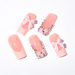 Faux ongles trapèze roses avec nœuds 3D et strass irisés de style French chic