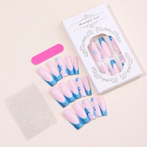 Dettaglio di unghie finte lunghe trapezoidali con glitter blu e piccoli fiori decorati