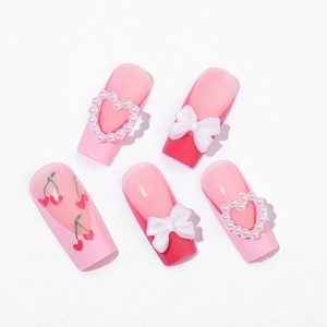 Pink gradient press-on nails with 3D bows, pearl hearts, and cherry patterns for Valentine
