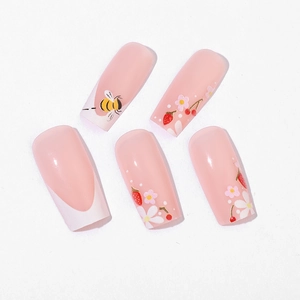 French tip press-on nails featuring cute bees, strawberries and floral designs