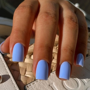 Close-up of matte sky blue short square press-on nails with minimalist square-oval finish