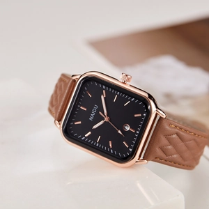 Detailed side view of rose gold rectangular watch with brown quilted leather strap