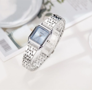 Gros plan d'une montre à quartz carrée argentée avec cadran bleu clair et bracelet en acier
