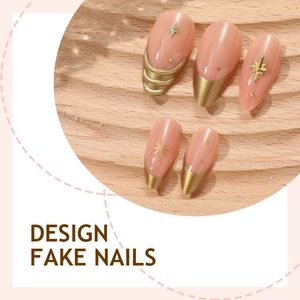 Faux ongles amande rose nude avec éléments d'étoiles dorées et pointes françaises