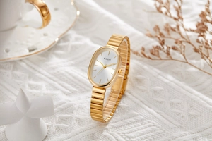 Detail of elegant gold oval quartz watch with silver dial on a soft knit background