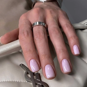 Silver screw design ring with inset diamond shown against a luxury leather handbag