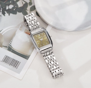 Détail d'une montre carrée à quartz avec cadran champagne et bracelet en acier argenté