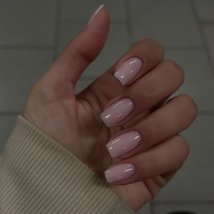 Close-up of glossy soft pink press-on nails in short square shape with jelly finish