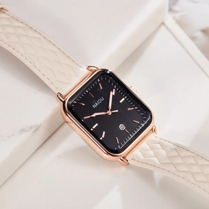 Detailed macro view of rectangular rose gold watch with beige quilted leather strap