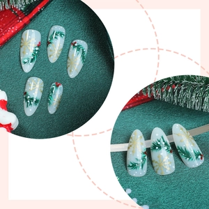 Christmas almond press-on nails with green pine branch and gold snowflake patterns