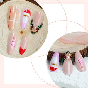 Almond press-on nails with Christmas tree art, red French tips, and rhinestone accents