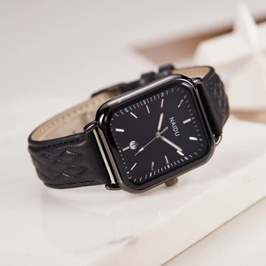 Detail of rectangular watch with black dial and leather band featuring diamond texture