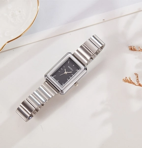 Detail of elegant rectangular black dial watch with silver bamboo link steel strap