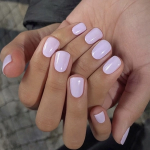 Close-up of lilac glossy press-on nails in short round shape on a natural hand pose