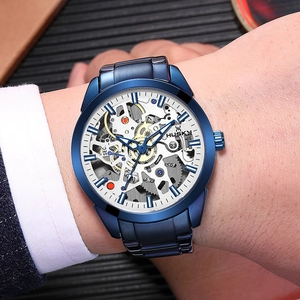 Close-up of blue skeleton mechanical watch with visible gears worn on a male wrist