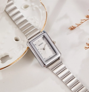 Detailed close-up of rectangular silver quartz watch with elegant chain strap and white dial