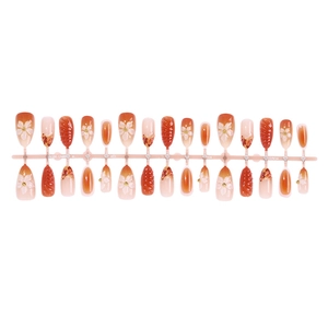 Almond-shaped press-on nails with 3D embossed flowers and warm orange gradients