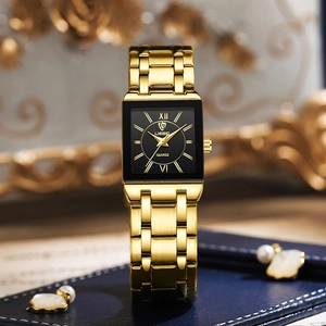 Detailed close-up of a gold rectangular quartz watch with a black dial on a blue box