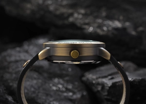 Close-up of vintage bronze mechanical watch case with brushed metal finish and tachymeter scale