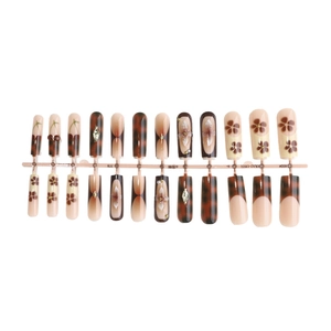 Long coffin leopard print press-on nails with red cherry and floral patterns on stand