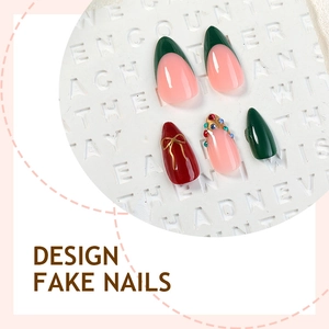 Red French tip press-on nails with Christmas rhinestones and gold bow accents