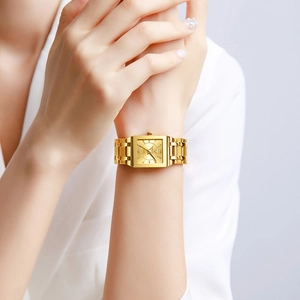 Elegant gold square quartz watch with H-link metal bracelet on a female wrist