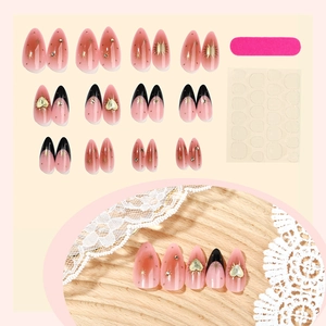 French almond press-on nails set with pink gradient, black tips and gold heart accents