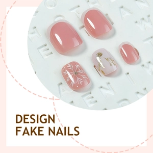 Winter Christmas press-on nails with pink base, white snowflakes and gold foil accents