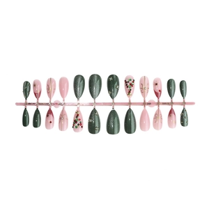 Christmas press-on nail set with green bow and diamond tree accents on pink and silver nails