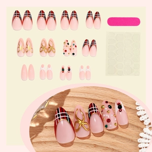Faux ongles amande de Noël avec motifs écossais, nœuds dorés et cristaux scintillants