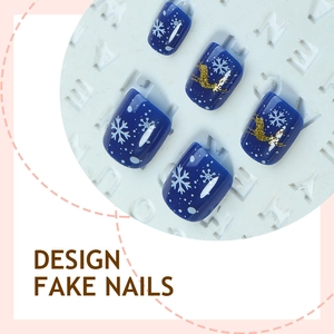 Blue Christmas press-on nails with white snowflake and gold reindeer designs on display