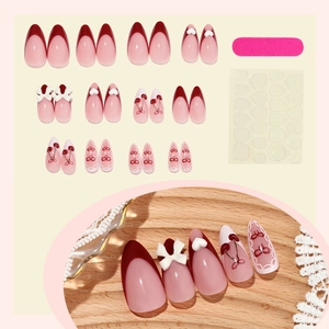 French tip press-on nails with cherry and heart patterns and white bow accents